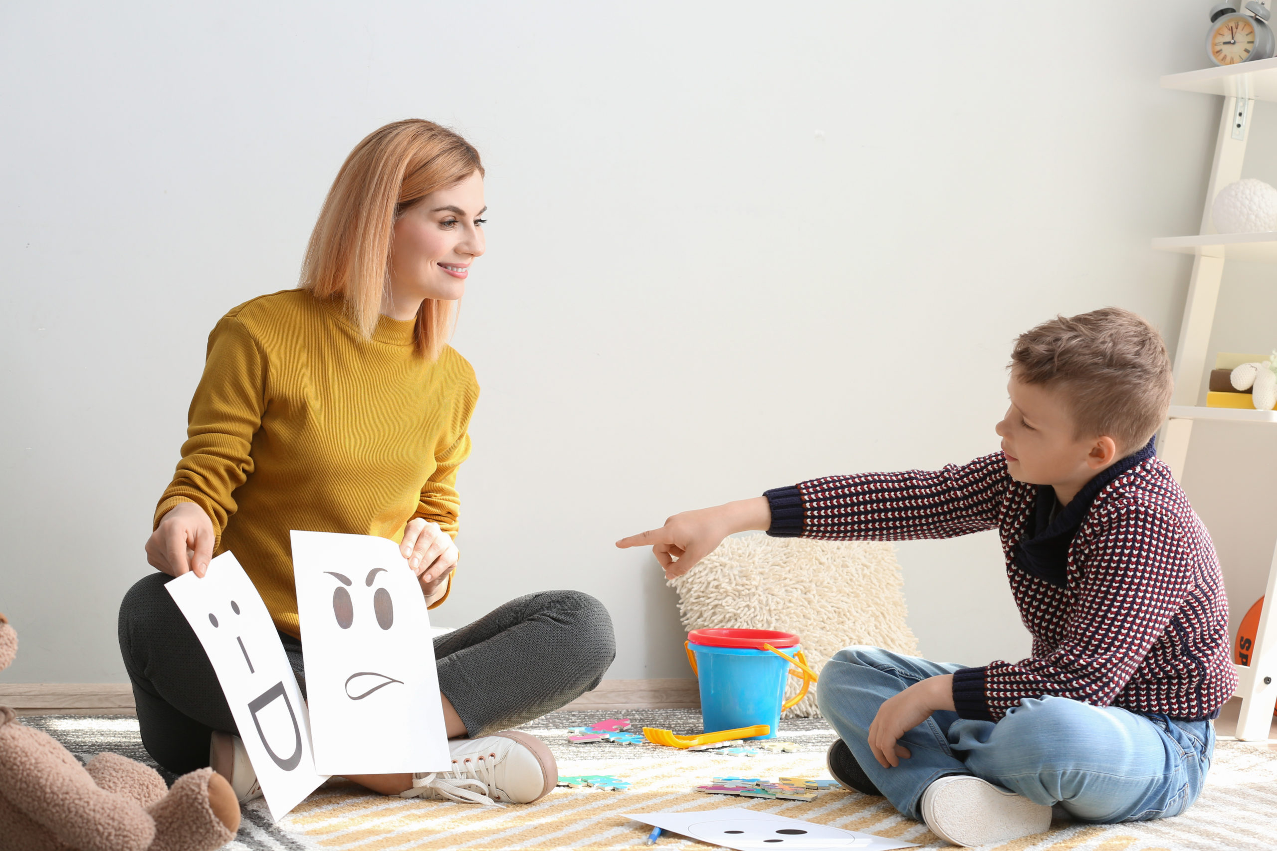 Female psychologist working with boy suffering from autistic disorder